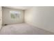 An empty bedroom with neutral carpet, a window and plain white walls at 11026 N 28Th Dr # 81, Phoenix, AZ 85029