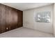 Cozy bedroom featuring wood paneling and a window with blinds for natural light at 11026 N 28Th Dr # 81, Phoenix, AZ 85029