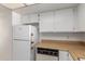 This kitchen has white cabinetry, appliances, a tiled floor, and laminate countertops at 11026 N 28Th Dr # 81, Phoenix, AZ 85029