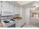 This kitchen has white cabinetry and appliances with an adjacent dining area at 11026 N 28Th Dr # 81, Phoenix, AZ 85029