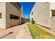 Exterior walkway between buildings with lush green grass, xeriscaping, and a clear blue sky at 11026 N 28Th Dr # 81, Phoenix, AZ 85029
