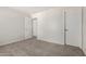 Clean, carpeted bedroom with modern white walls and an open doorway at 11871 W Sherman St, Avondale, AZ 85323