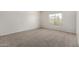 Bright bedroom with neutral carpet, window, and freshly painted walls at 11871 W Sherman St, Avondale, AZ 85323