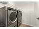 A laundry room includes modern gray front-loading washer and dryer at 11871 W Sherman St, Avondale, AZ 85323
