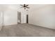 Spacious main bedroom with a ceiling fan and carpet flooring leads into the main bathroom at 11871 W Sherman St, Avondale, AZ 85323