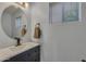 Bright and airy bathroom featuring a modern vanity, sink, and a round mirror, creating a clean and stylish space at 12720 W Cantenia Rd, Avondale, AZ 85392
