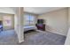 Bright bedroom featuring neutral walls, carpet, a twin bed, and a dresser with TV, creating a cozy and functional space at 12720 W Cantenia Rd, Avondale, AZ 85392