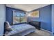 Blue bedroom with large window view, carpet, a black dresser, and a ceiling fan, creating a cozy and private retreat at 12720 W Cantenia Rd, Avondale, AZ 85392
