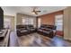Living room with wood floors, ceiling fan, and comfortable leather sofas at 12720 W Cantenia Rd, Avondale, AZ 85392
