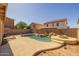 Backyard pool and patio area featuring unique rock waterfall features and mature landscaping at 12720 W Cantenia Rd, Avondale, AZ 85392