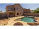 Backyard pool and patio featuring unique rock waterfall features, a built-in firepit, and privacy at 12720 W Cantenia Rd, Avondale, AZ 85392
