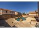 Backyard pool and patio area featuring unique rock waterfall features and desert landscaping at 12720 W Cantenia Rd, Avondale, AZ 85392