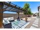 Backyard seating area under a pergola with comfortable patio furniture and accent landscaping and hardscaping at 1359 E 12Th St, Casa Grande, AZ 85122