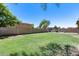 Lush backyard with green grass, an outdoor seating area under a wood pergola, and mature shade trees at 1359 E 12Th St, Casa Grande, AZ 85122