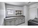 Bright laundry room with white cabinets, countertops, window, and modern appliances at 1359 E 12Th St, Casa Grande, AZ 85122
