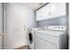 A laundry room with a modern washer and dryer and a view of the exterior door at 1403 W Goldfinch Way, Chandler, AZ 85286