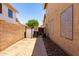 Narrow side yard with sidewalk, block wall, and minimal landscaping at 1403 W Goldfinch Way, Chandler, AZ 85286