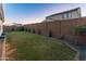 Expansive backyard boasts a green lawn, swing set, and mature landscaping for outdoor enjoyment at 14274 W Sand Hills Rd, Surprise, AZ 85387