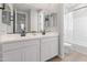 Bright bathroom featuring double sinks, white cabinetry, and sleek black fixtures at 14274 W Sand Hills Rd, Surprise, AZ 85387