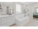 Bright bathroom featuring double sinks, a soaking tub and large mirrors at 14274 W Sand Hills Rd, Surprise, AZ 85387
