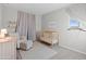 Comfortable Bedroom with crib, glider, and ottoman, featuring neutral tones and natural light at 14274 W Sand Hills Rd, Surprise, AZ 85387