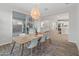 Bright dining area features modern lighting, a light wood table with seating for six, and sliding glass doors to the patio at 14274 W Sand Hills Rd, Surprise, AZ 85387