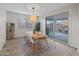 Dining area with sleek wood-look flooring, modern lighting, and sliding glass doors leading to the outdoor patio at 14274 W Sand Hills Rd, Surprise, AZ 85387