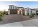 Charming two-story home featuring a manicured front yard, brick driveway, and a welcoming entrance at 14274 W Sand Hills Rd, Surprise, AZ 85387