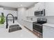 Modern white kitchen with stainless steel appliances, quartz countertops, and sleek cabinetry at 14274 W Sand Hills Rd, Surprise, AZ 85387