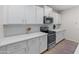 Modern kitchen features stainless steel appliances, white cabinets, and ample counter space for cooking at 14274 W Sand Hills Rd, Surprise, AZ 85387
