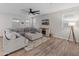 Cozy living room with a large sectional sofa, wood-look flooring, modern ceiling fan, and a fireplace at 14274 W Sand Hills Rd, Surprise, AZ 85387