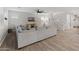 Bright living room featuring a sectional sofa, modern ceiling fan, wood-look flooring, and staircase access at 14274 W Sand Hills Rd, Surprise, AZ 85387