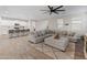 Inviting living area with a spacious sectional sofa, modern kitchen, and stylish wood-look flooring at 14274 W Sand Hills Rd, Surprise, AZ 85387