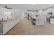 Open-concept living area with a spacious kitchen, white cabinets, stainless steel appliances, and modern wood-look flooring at 14274 W Sand Hills Rd, Surprise, AZ 85387