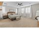Bright main bedroom with neutral tones, a ceiling fan, and large windows, creating a peaceful retreat at 14274 W Sand Hills Rd, Surprise, AZ 85387