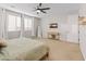 Spacious main bedroom with neutral walls, wood-look floors, a ceiling fan, and lots of natural light at 14274 W Sand Hills Rd, Surprise, AZ 85387