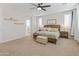 Bright main bedroom featuring a ceiling fan, neutral carpeting, and plenty of natural light at 14274 W Sand Hills Rd, Surprise, AZ 85387