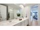 Bright bathroom boasts double sinks, white cabinetry and large mirrors; access to adjacent room at 1482 W Ridge Rd, Apache Junction, AZ 85120