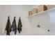 Convenient laundry area with overhead shelving and hooks for towels, offering efficient storage solutions at 1482 W Ridge Rd, Apache Junction, AZ 85120