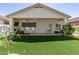 A well-manicured backyard featuring an artificial lawn, a covered patio, and exterior landscaping at 15034 N 30Th St, Phoenix, AZ 85032