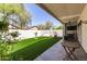 Large backyard featuring a well-maintained artificial lawn and covered patio with outdoor seating at 15034 N 30Th St, Phoenix, AZ 85032
