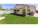 A spacious backyard features green artificial turf, covered patio with furniture, and lovely exterior landscape at 15034 N 30Th St, Phoenix, AZ 85032