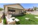 A beautifully landscaped backyard with artificial turf, a covered patio, and cozy outdoor seating arrangement at 15034 N 30Th St, Phoenix, AZ 85032