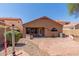 Back exterior of home with a brick patio, covered patio, an arched window and privacy fence at 1534 E Mineral Rd, Gilbert, AZ 85234