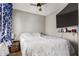 Cozy bedroom with a ceiling fan, a television, and a comfortable bed with a white patterned comforter at 1534 E Mineral Rd, Gilbert, AZ 85234