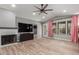 Bright living room with hardwood floors, a fireplace, a ceiling fan, and many windows at 1534 E Mineral Rd, Gilbert, AZ 85234