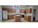 Bright kitchen featuring oak cabinets, a center island, white appliances, and tile flooring at 16021 N 30Th St # 113, Phoenix, AZ 85032