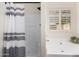 Bright bathroom with tiled shower, soaking tub, and a window with plantation shutters at 16118 W Morning Glory St, Goodyear, AZ 85338