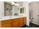 Well-lit bathroom with dual sinks, wood cabinets, and a separate toilet room at 16118 W Morning Glory St, Goodyear, AZ 85338