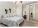 Well-lit bedroom with ensuite bathroom, ceiling fan, and closet with mirror doors at 16118 W Morning Glory St, Goodyear, AZ 85338